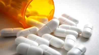 close up on a bottle of prescription drugs and hydrocodone pills falling out of it shutterstock 1032081463